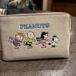 Coach X Peanuts Corner Zip Wristlet
With Snoopy And Friends Motif